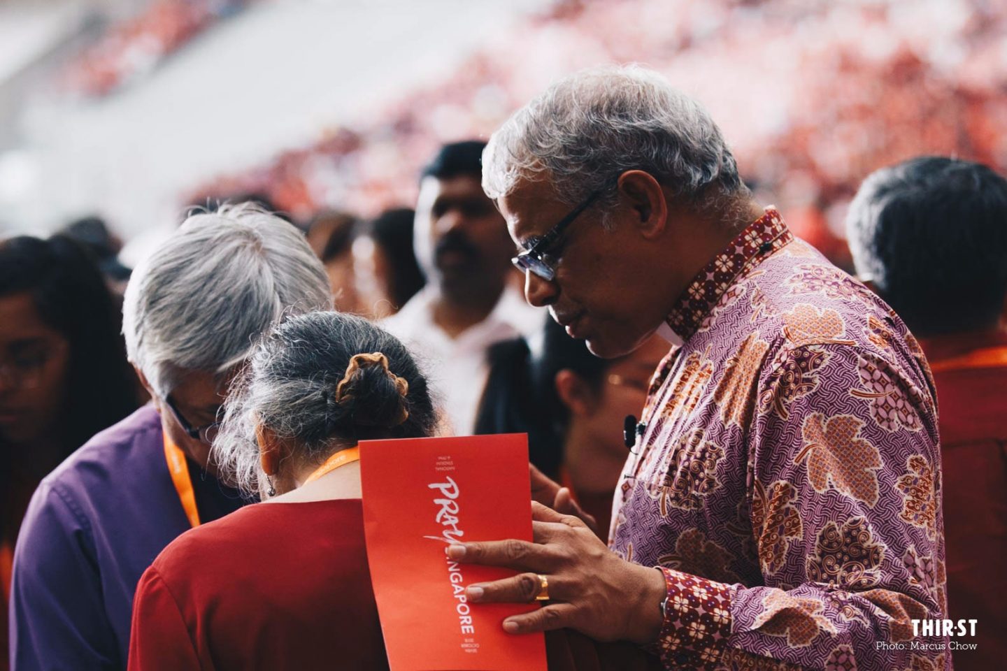 Bishop Rennis Ponniah praying with attendees at PraySingapore.