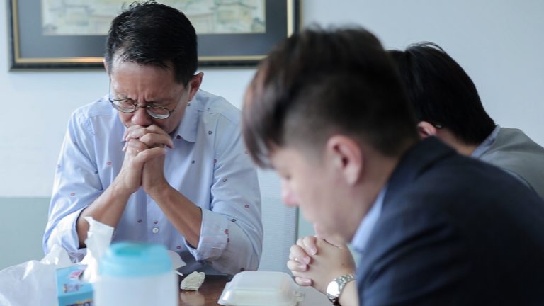 Daniel Goh (left) praying together with the others in the Tuesday lunch fellowship.