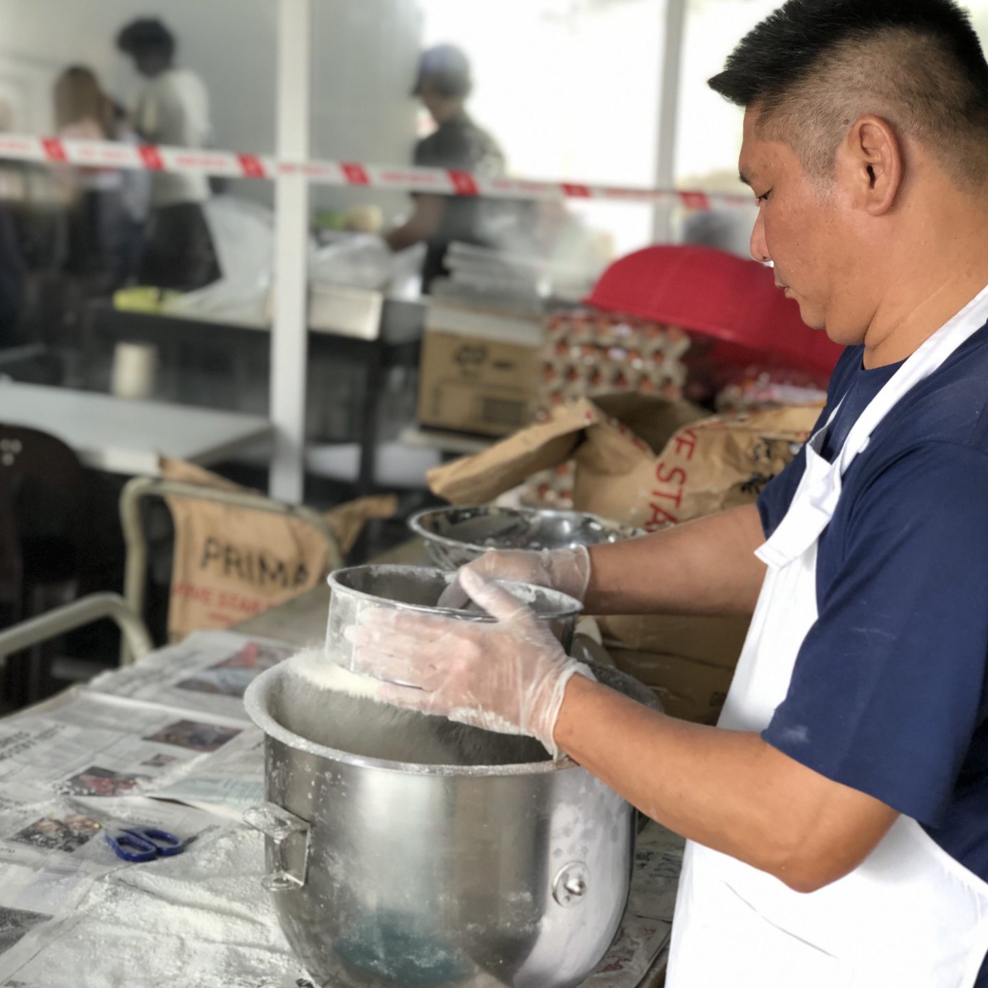A resident sifting flour, preparing the next batch of pastry. THP uses 2,500kg of flour and 3,000 sticks of SCS butter every Chinese New Year. Photo by Geraldine Tan.