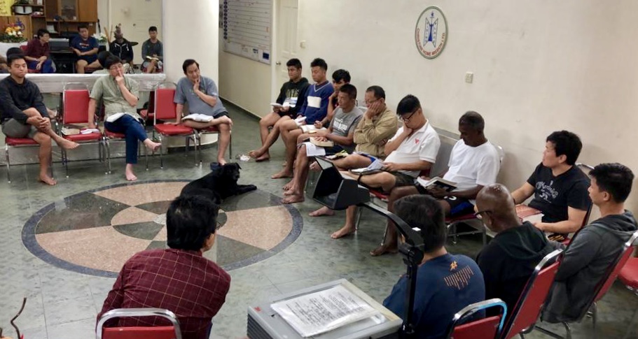 Pastor Philip (seated, third from left) at a recent family prayer meeting, which happens every Saturday morning at The Hiding Place. It is a time where staff and residents come together and share their learnings from the week and prayer needs. Photo courtesy of Caleb Tan.