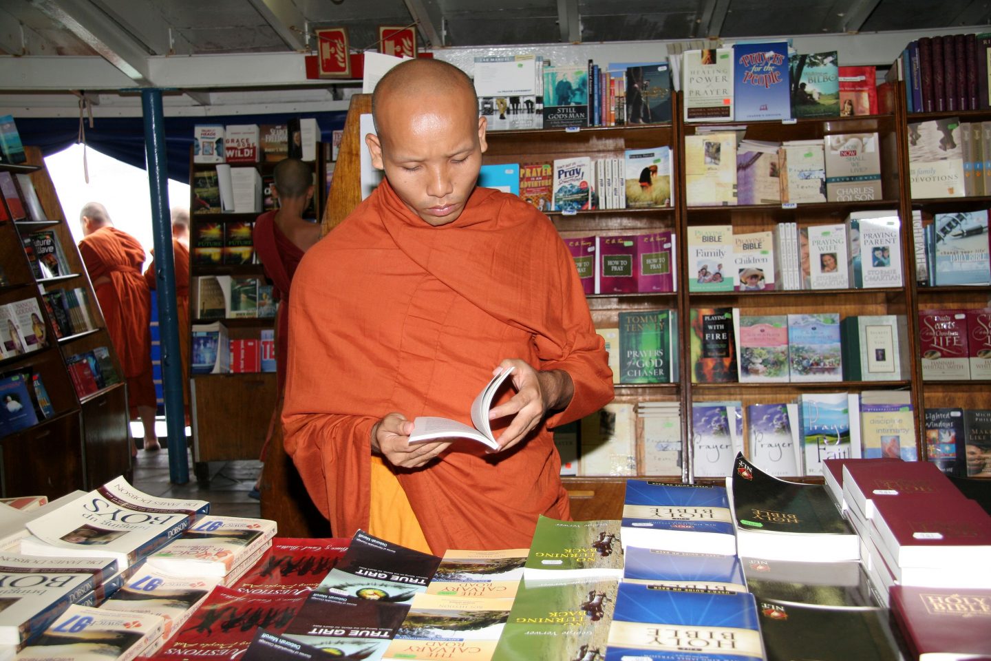 A Buddhist monk reads Christian literature with interest in the book fair in Sattahip, Thailand in 2006. Photo by Stephanie Vaupel.