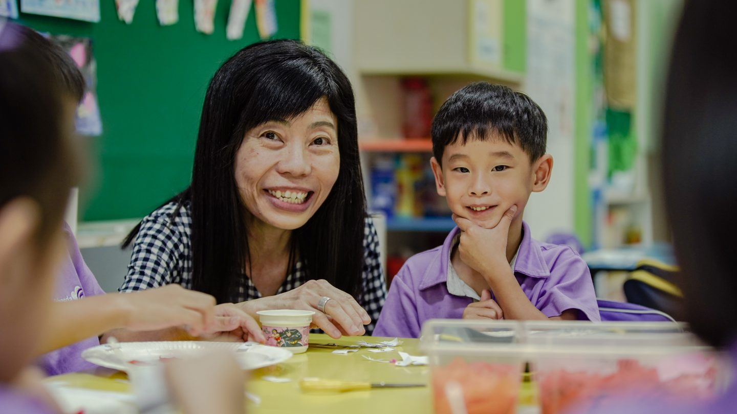 Ethan poses for a photo with Chels Tan, 51, who is the Principal of Bethesda (Bedok-Tampines) Kindergarten. Pastor Felicia attributes his drastic improvement in academics to the nurturing teachers and environment of the school. Photo by Ang Wei Ming.