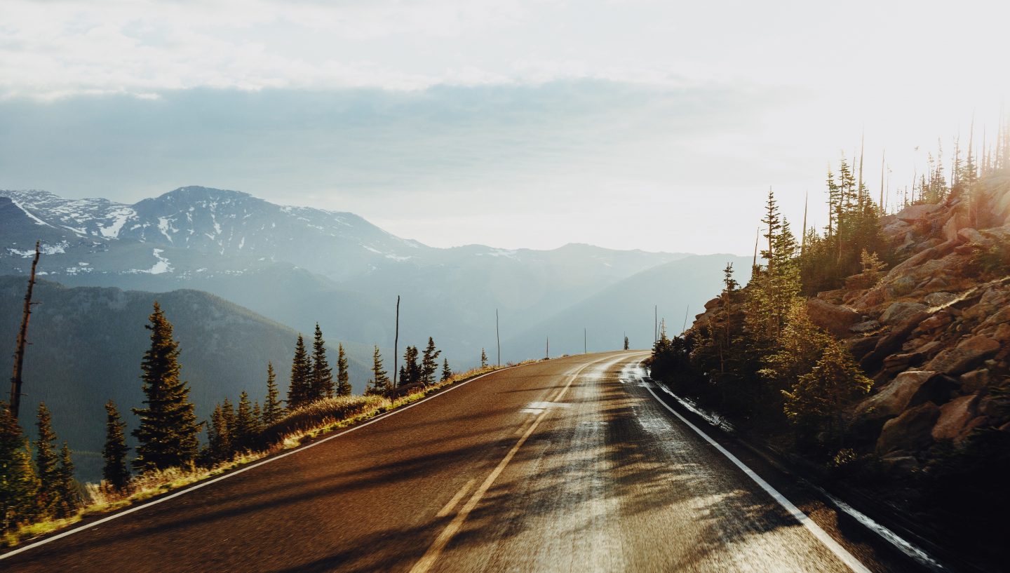 Many roads in Colorado curve back and forth around streams, hills, and mountain passes. On the morning of Yancey's accident, he was surprised by patches of ice on the road. As he headed downhill into a curve, his car began to fishtail. It eventually rolled into an embankment. Photo of a road in Colorado by Zach Miles on Unsplash.