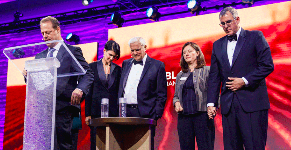 From right, Michael Ramsden and his wife, Anne, Ravi Zacharias and Sarah Zacharias Davis on stage when the leadership transition was announced. Photo by RZIM.