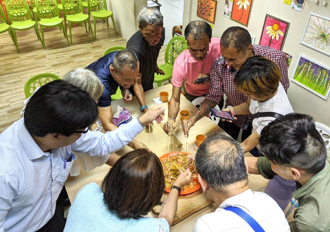 A group of seven homeless people and three social workers and volunteers celebrated the Lunar New Year on January 29, 2020 by tossing a <i></noscript>yu sheng</i> at the Homeless Night Cafe run by Presbyterian Community Services and Homeless Hearts of Singapore. Faces have been blurred out to protect their identity. Photo by Gracia Lee.