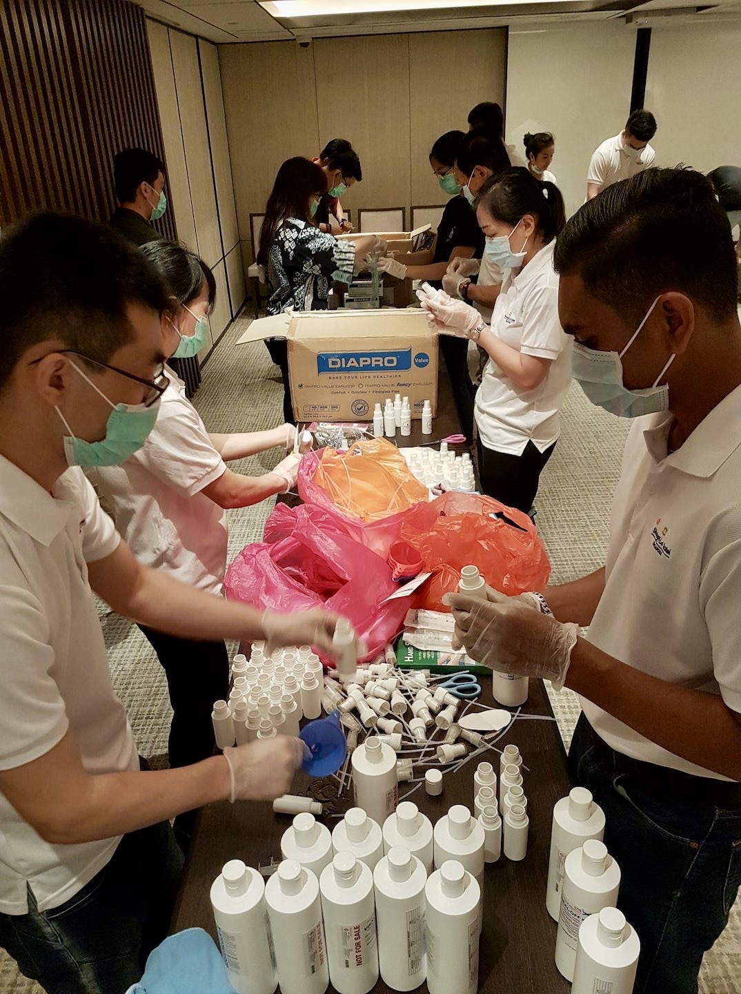 Volunteers from Care Corner and Shangri-La Hotel putting together the care packs for vulnerable seniors. Photo from Shangri-La Hotel, Singapore's Facebook page.