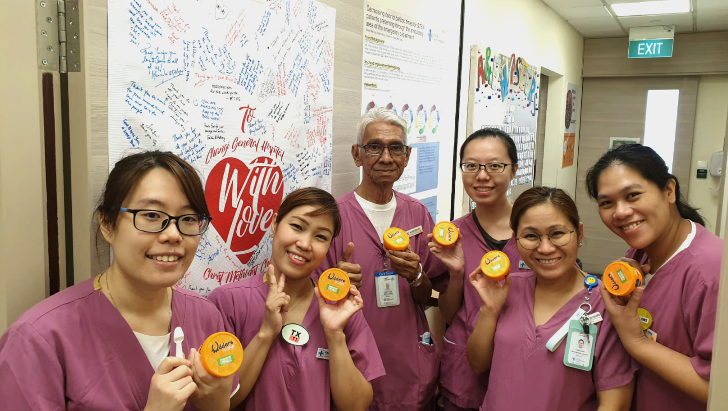 Nurses from Changi General Hospital's accident and emergency department and a healthcare attendant enjoying a cup of Udders ice cream sponsored by Christ Methodist Church. In the background is a poster of well wishes and words of appreciation penned by church members. Photo courtesy of Changi General Hospital.