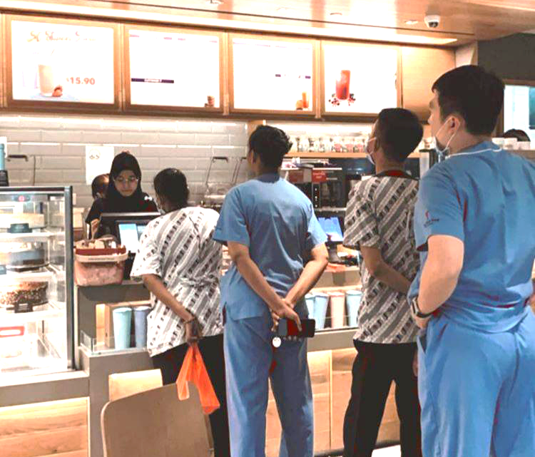 Healthcare workers from Tan Tock Seng Hospital queuing up to redeem their free drink at Coffee Bean after a group of friends decided to pool together funds to sponsor them. Photo taken from the Ray of Hope crowdfunding site.