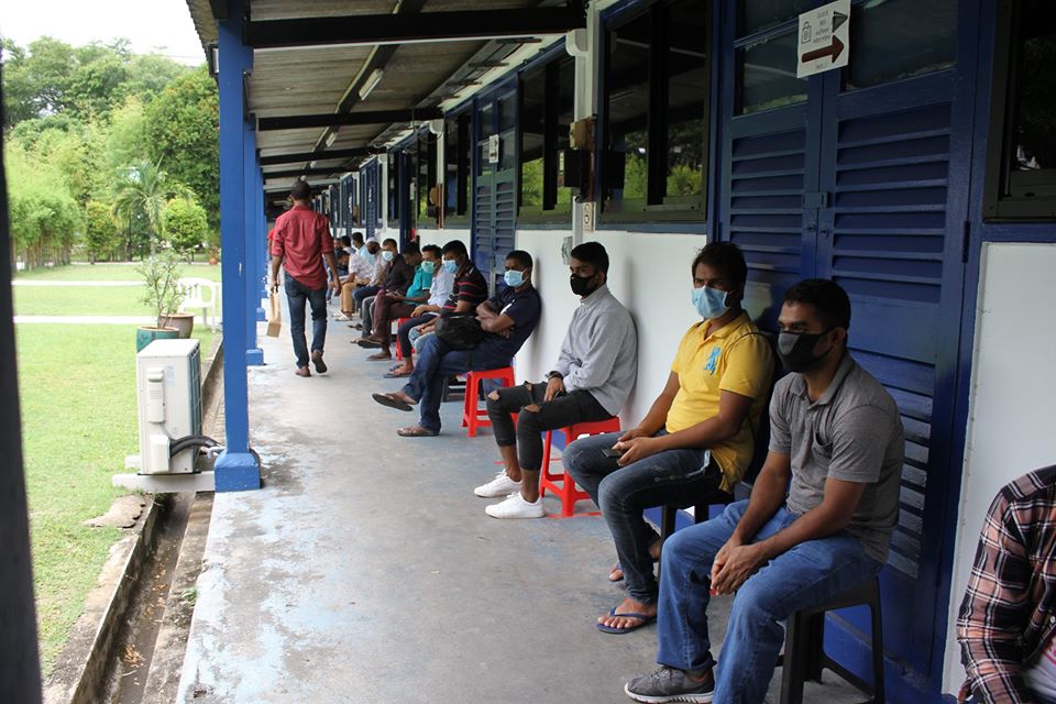 Migrant workers queuing up to collect a healthcare packet given out by Healthserve yesterday. Photo taken from Healthserve's Facebook Page.