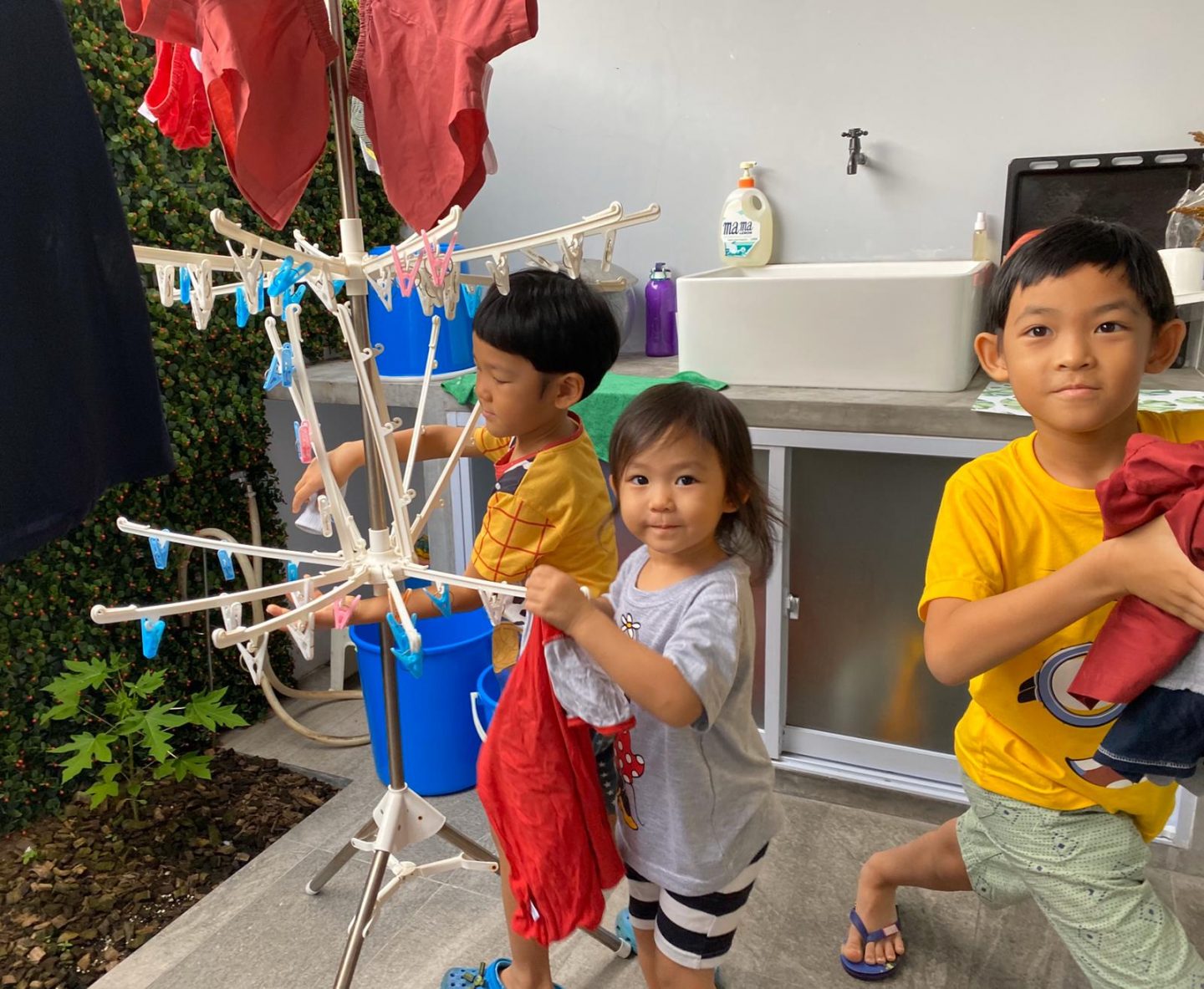 The Tan children – Joshua, Deborah and Michael – working together to put out the laundry 