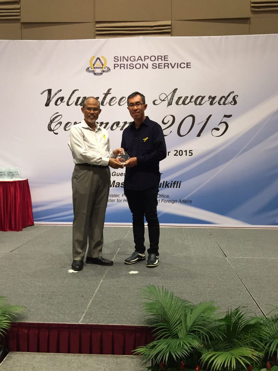 Teoh receiving an award from Mr Masagos Zulkifli for his long-term work in prison.