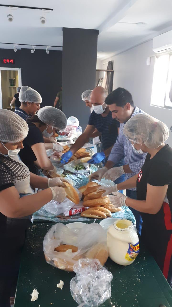 Church workers and volunteers preparing sandwiches to distribute to the grieving and workers who clean up the streets