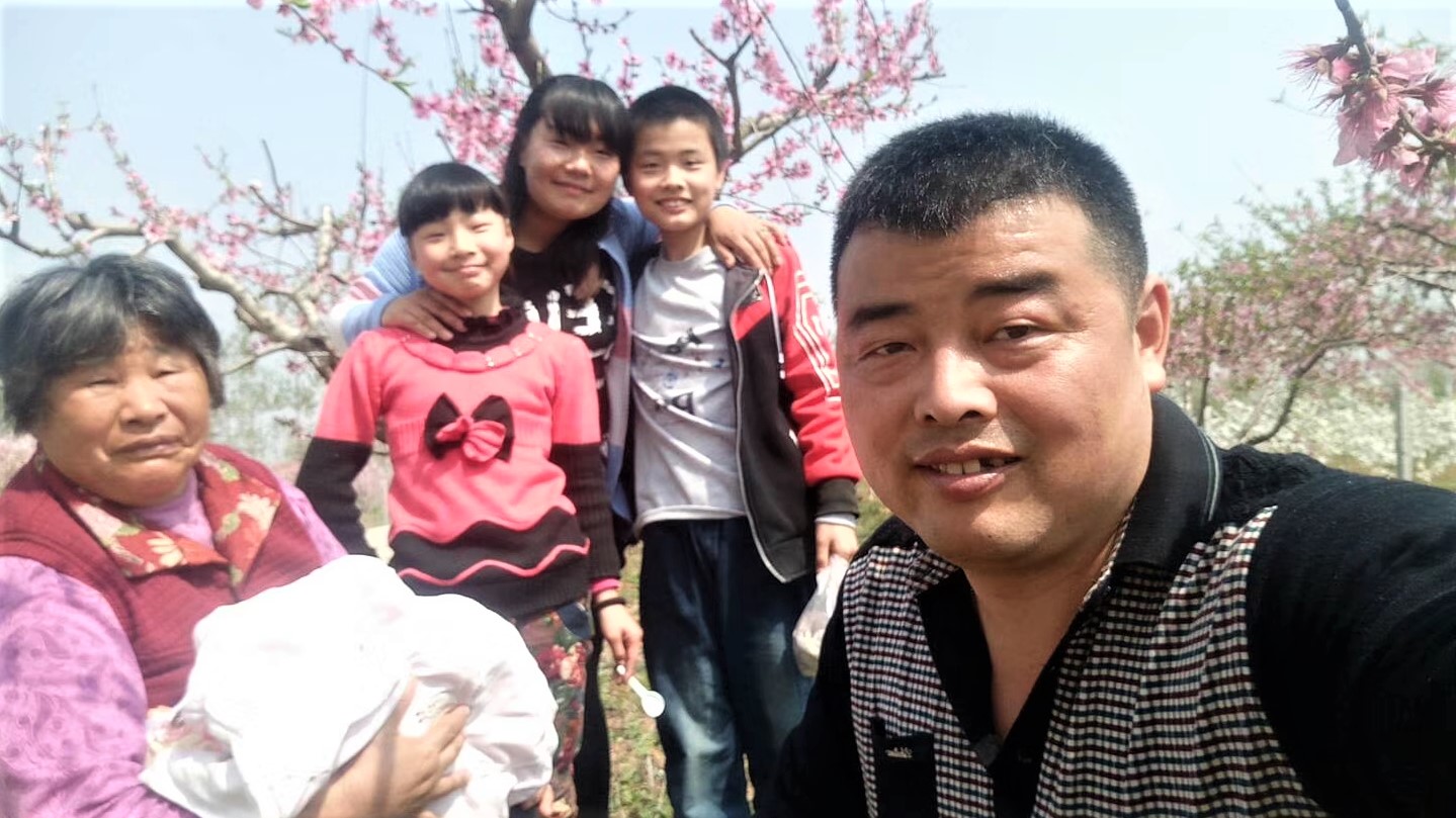 Huang (right) with his family (left to right) including his mother, daughter, wife and son in China during one of his home visits.
