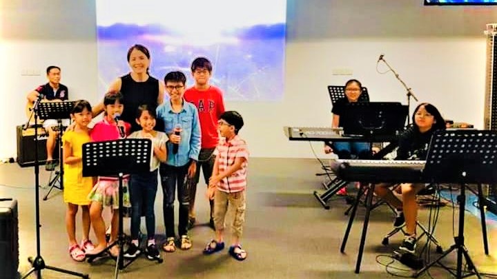 Gerald (far left), E-Laine (centre) and Anna (right, at the keyboard) leading  worship at Grace Star in Grace Methodist Church. Photo courtesy of Tan family.