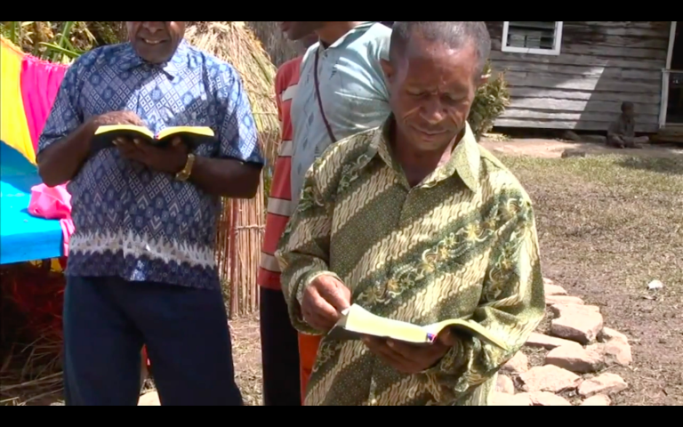 The Kimyal tribe from West Papua, Indonesia, holding a copy of the first New Testament in their language, as depicted in Imagine Life without the Bible. Screengrab from Imagine Life without the Bible.