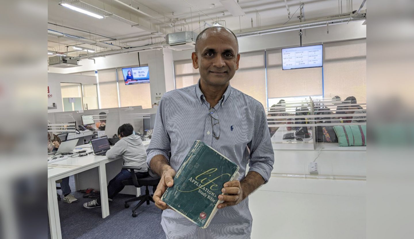 Anil David holding up the Bible he had pored over while in prison. After meeting God, who transformed his life, Anil went on to set up social enterprise call centre, Agape Connecting People, which employs ex-convicts, single mothers and people with disabilities. Photo by Gracia Lee.