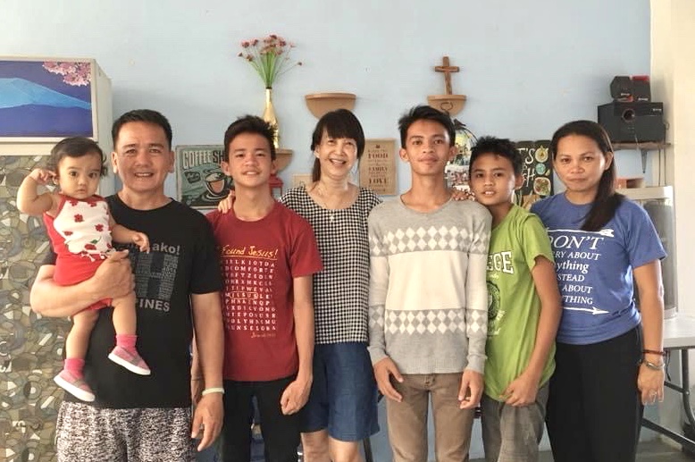 Jenny (middle) with Elijah (in red) and his family in the Philippines. 