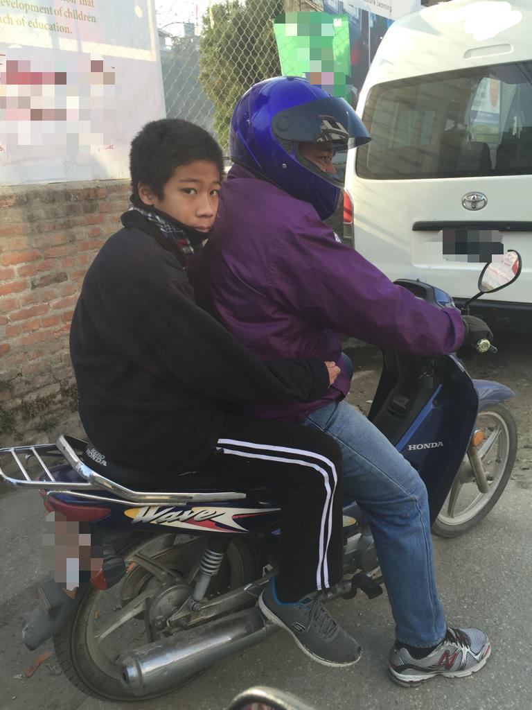 Ame and his son Amos on motorbike, their mode of transport. 