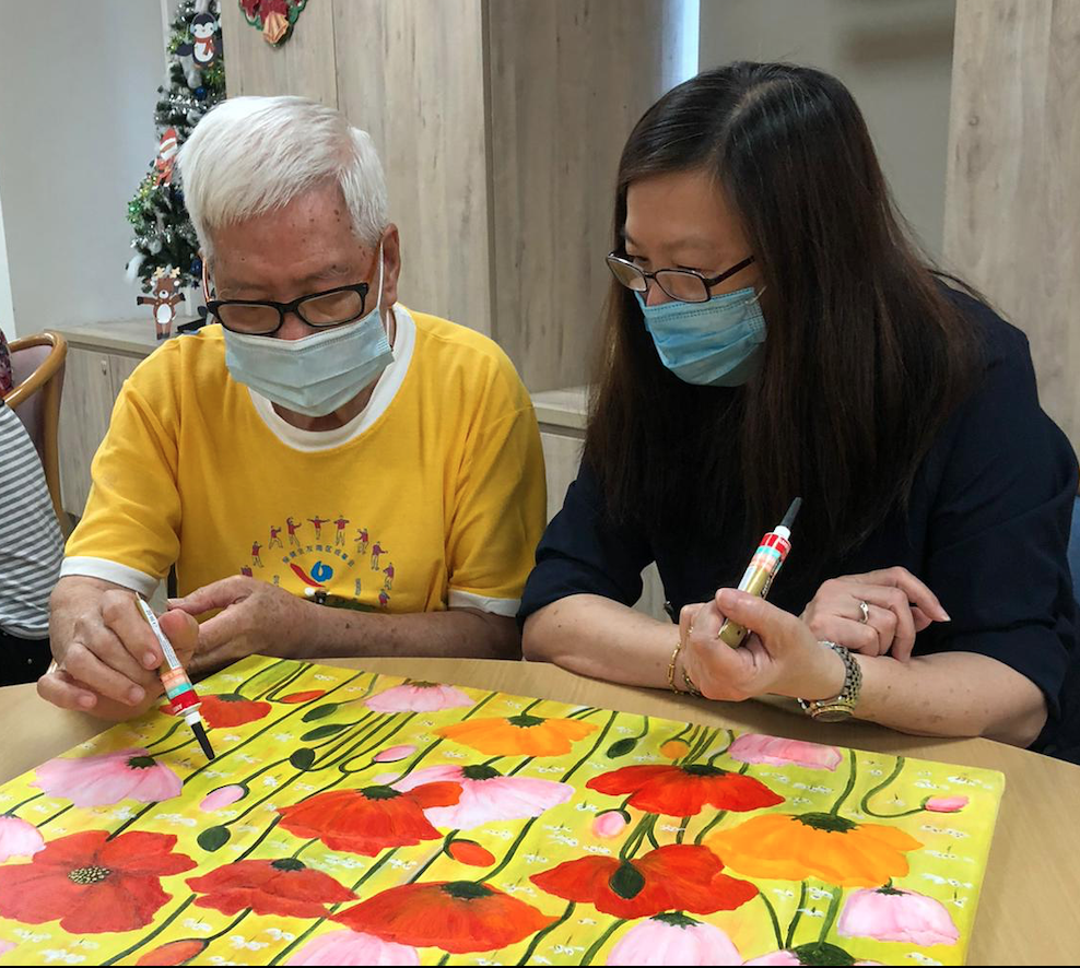 "The patients were very happy to take part in the project. They found the project meaningful, and were greatly encouraged," said Tracy Quah. In this picture, artist Glacy Soh guides a patient as he adds detail to the artwork.