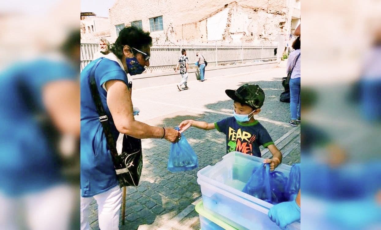 Seven-year-old Emmaus distributing food to the poor, homeless and refugees in Athens, Greece. All photos courtesy of Lim Nan.
