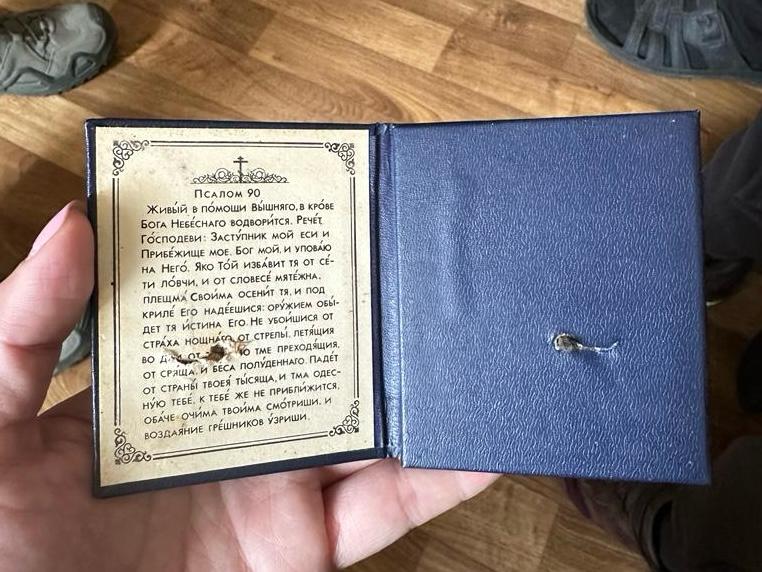 A small booklet with Psalm 90, which belongs to Ukrainian soldier Yaroslav. He was shot at behind enemy lines – but the bullet was stopped by this Bible booklet, in his left breast pocket.