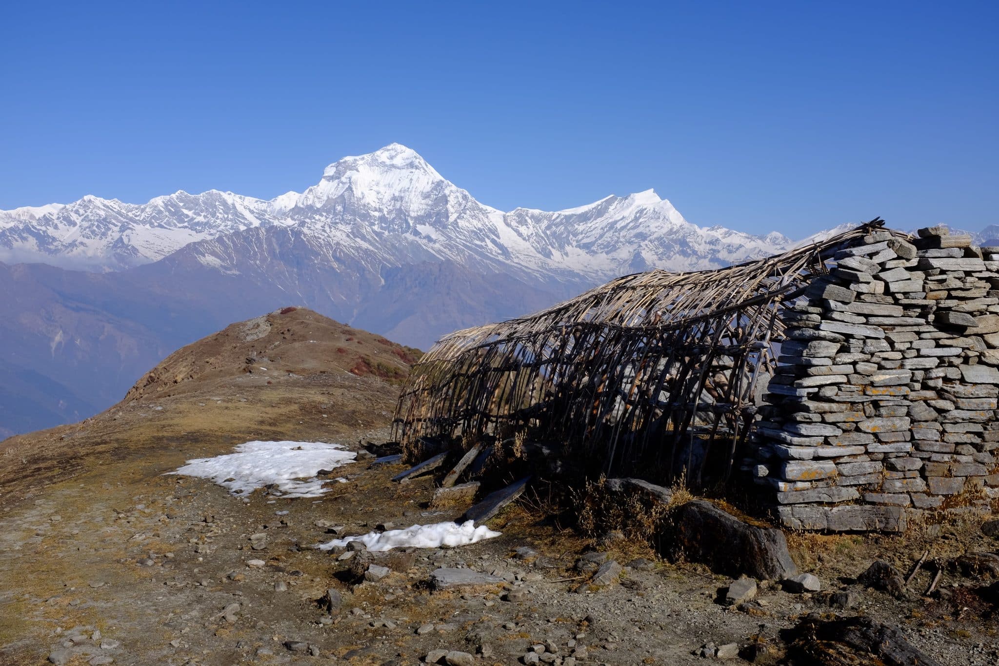 A threadbare shelter stands atop the barren and exposed Khopra Ridge in the shadow of great Mount Dhaulagiri, the seventh highest mountain on Earth. 