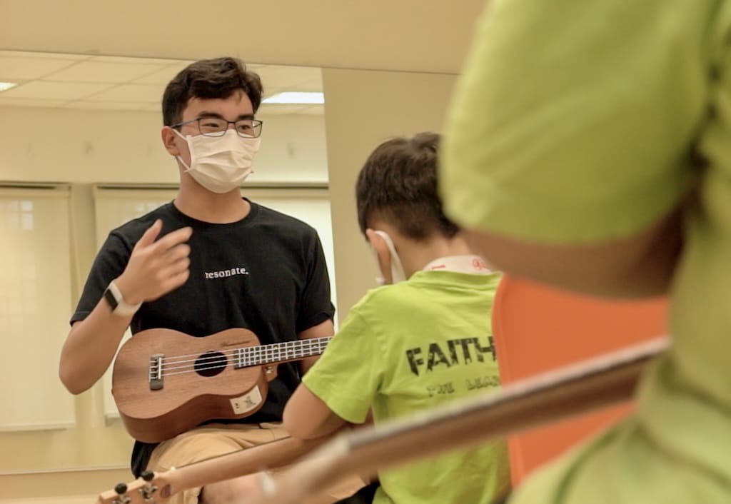 Elijah teaching ukulele at the centre where he primarily served