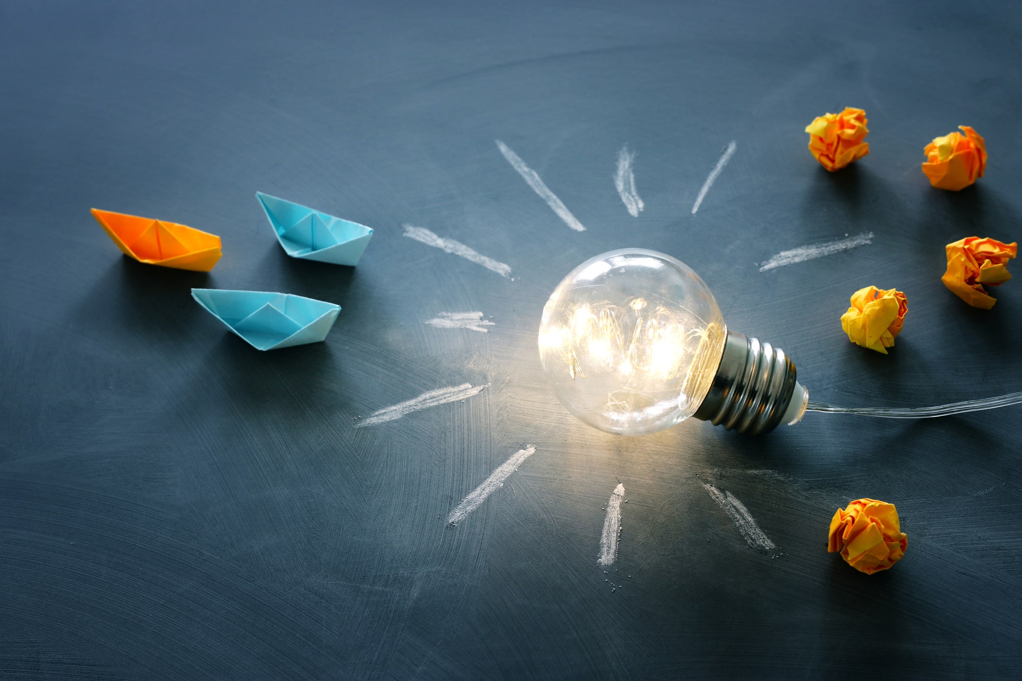 Education and leadership concept image. Creative idea and innovation. Light bulb as metaphor over blackboard