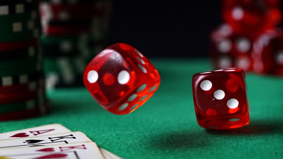 Red dice, casino chips, cards on green felt