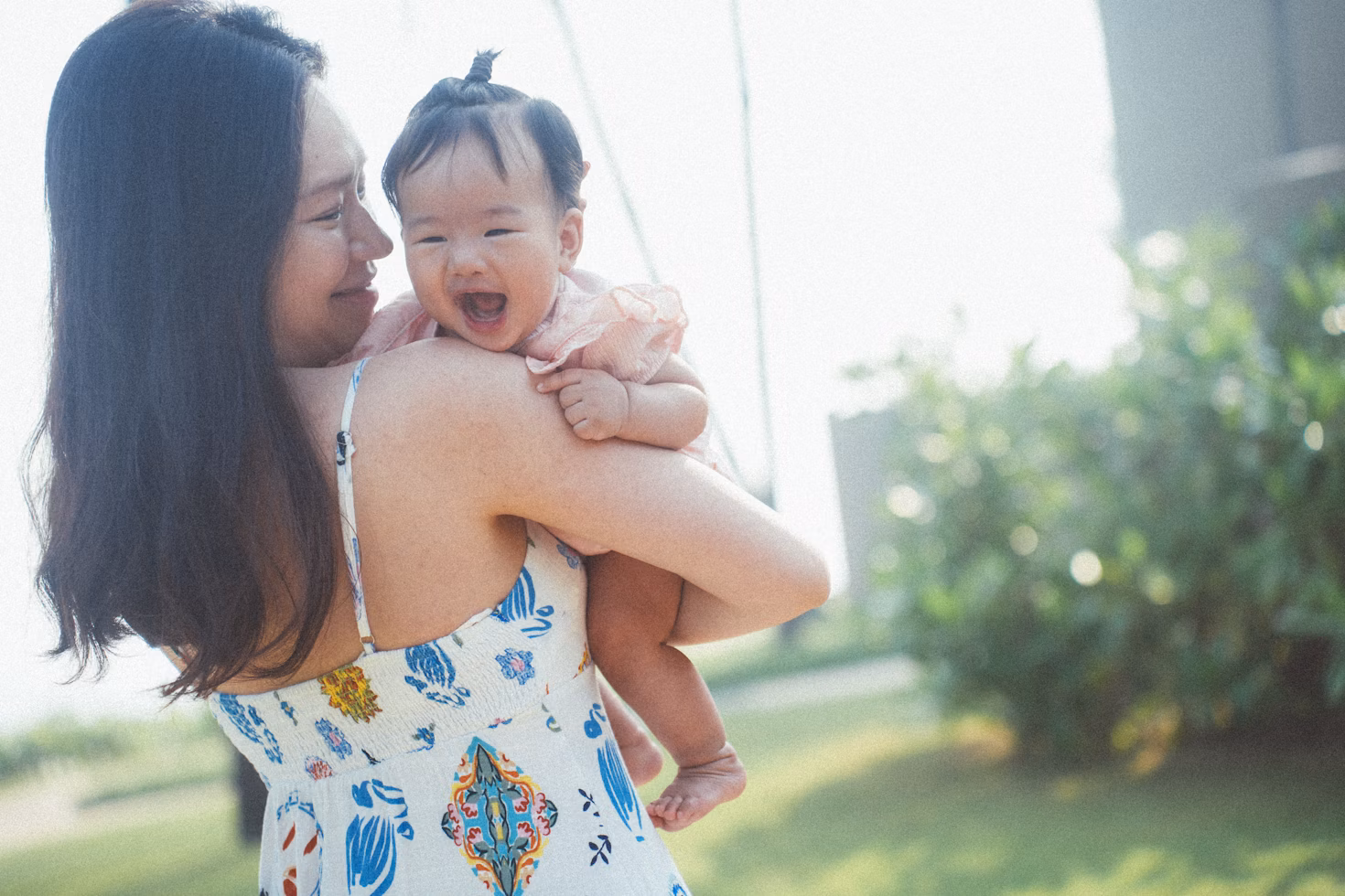Mother carrying infant smiling